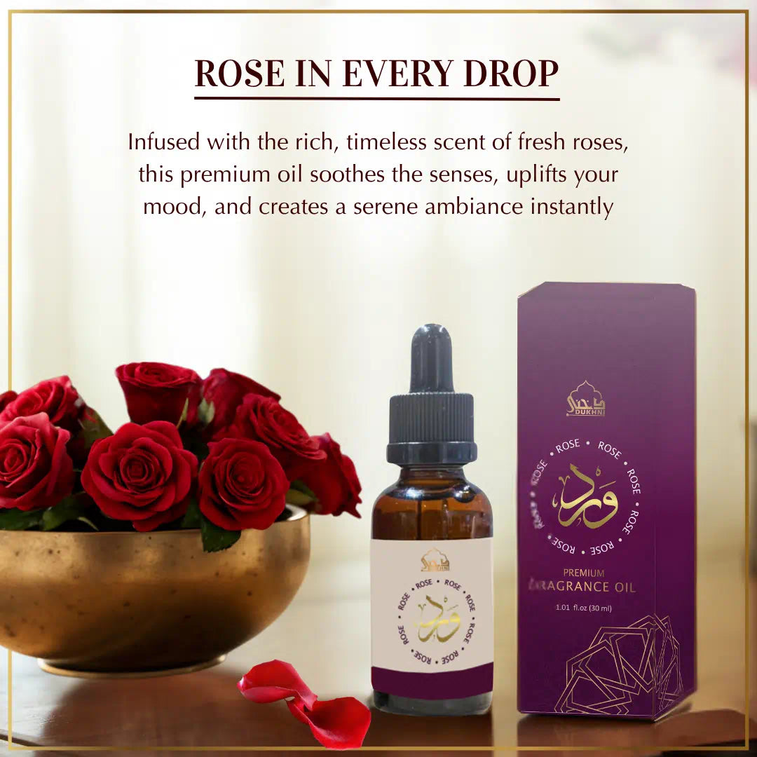 A bottle of premium fragrance oil with a dropper, a box, and a bowl of red roses on a light background.
